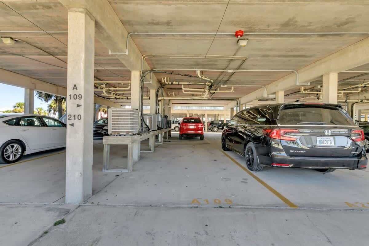 A multi-level parking garage with concrete pillars and overhead walkways.