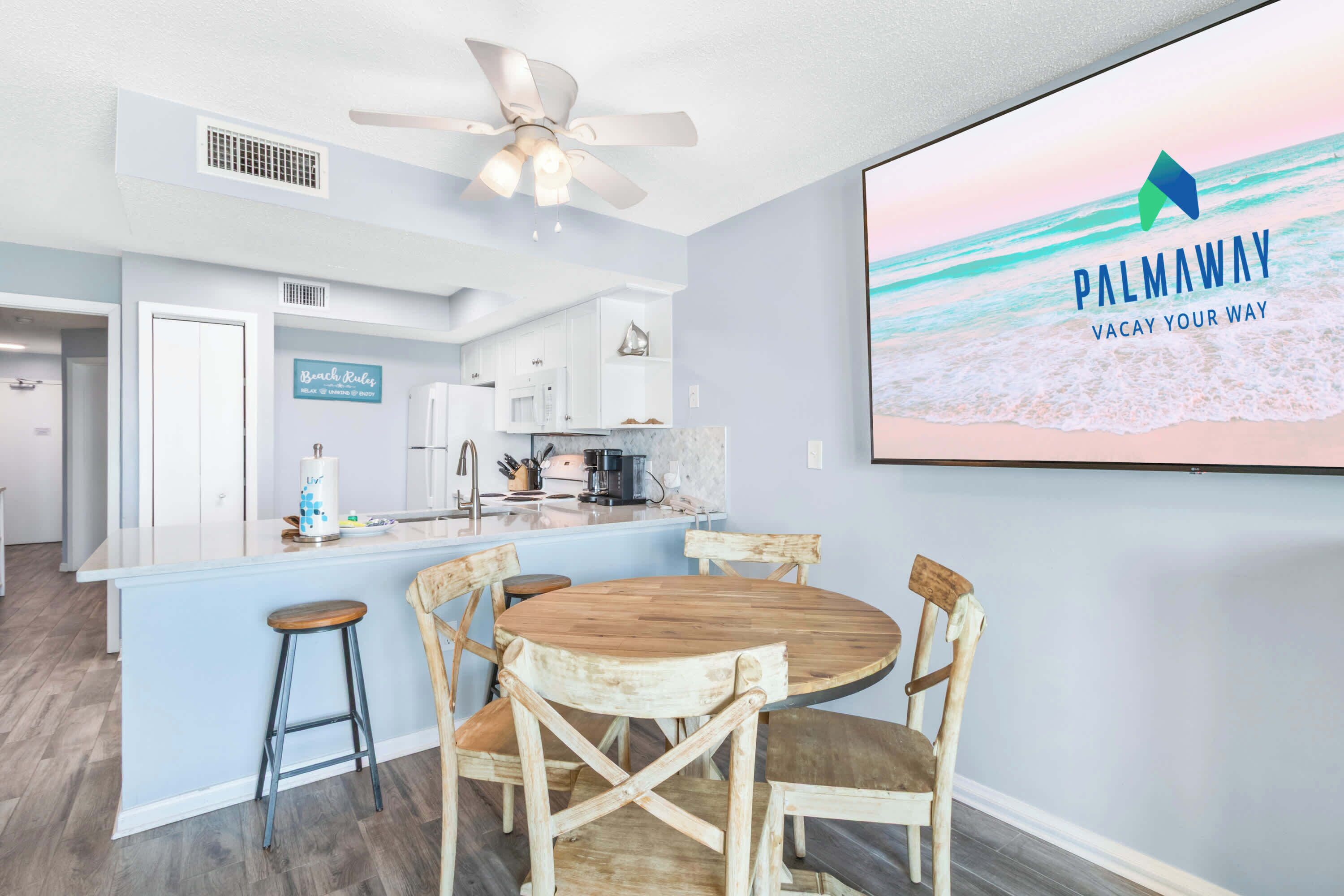 A modern kitchen with white cabinets, a wooden island, and a bar area.