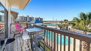 A balcony with a view of a swimming pool and surrounding buildings. - 1 bed Beach Pools Waterfront Boating Palmaway (Orange Beach)