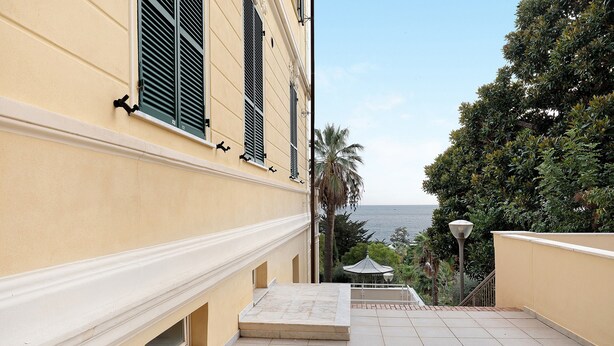 A balcony with a view of the sea, a palm tree, and a lamp post. - Holiday Home 'Appartamento A2' with Air Conditioning (Sanremo)