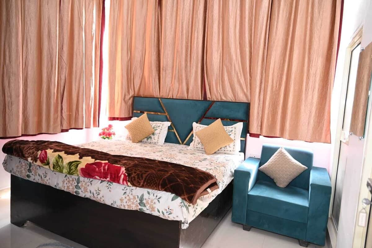 Une chambre à coucher avec un lit, deux oreillers, une table de chevet et une chaise.