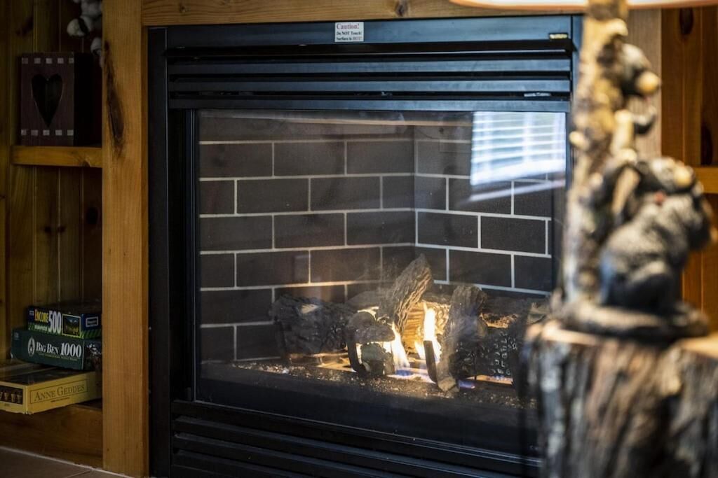 A fireplace with a brick surround and a warning label above it.