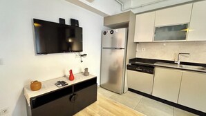 A modern kitchen with a built-in dishwasher, a stainless steel refrigerator, and a flat-screen TV mounted on the wall. - New apartment in the heart of Istanbul – near Istiklal and Galata (İstanbul)