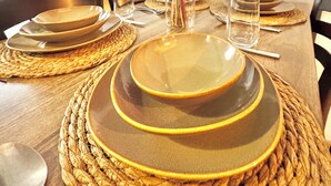 A dining table set with gold-rimmed plates, a clear glass, and a vase with flowers. - New apartment in the heart of Istanbul – near Istiklal and Galata (İstanbul)