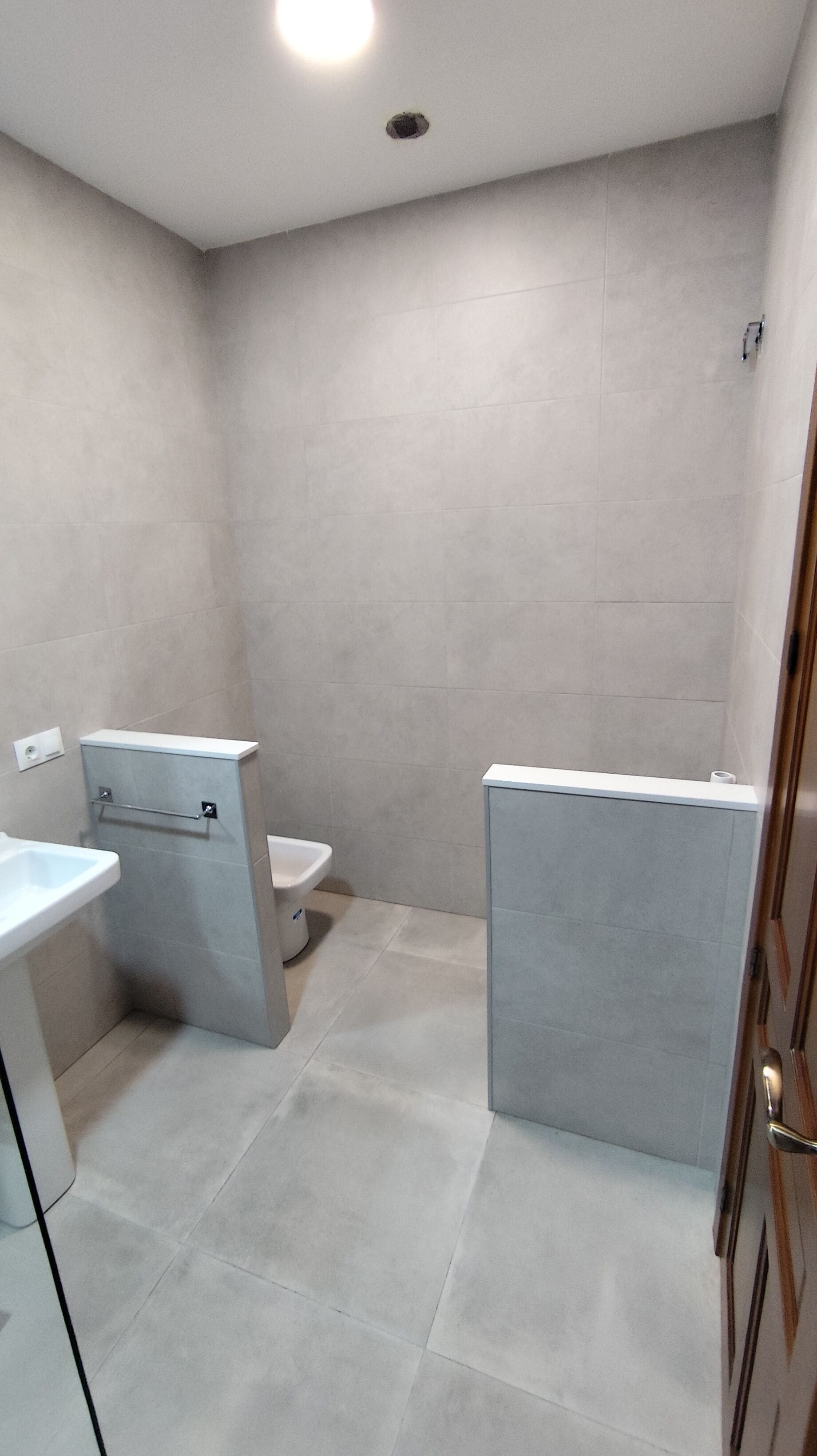 Une salle de bain comprenant des toilettes, un lavabo et un espace douche.
