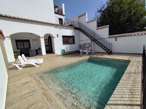 A swimming pool with clear water, surrounded by a wooden deck and white lounge chairs. - ABUELA MERCEDES & CATALINA RURAL HOUSE (20 beds) (Hornachuelos)