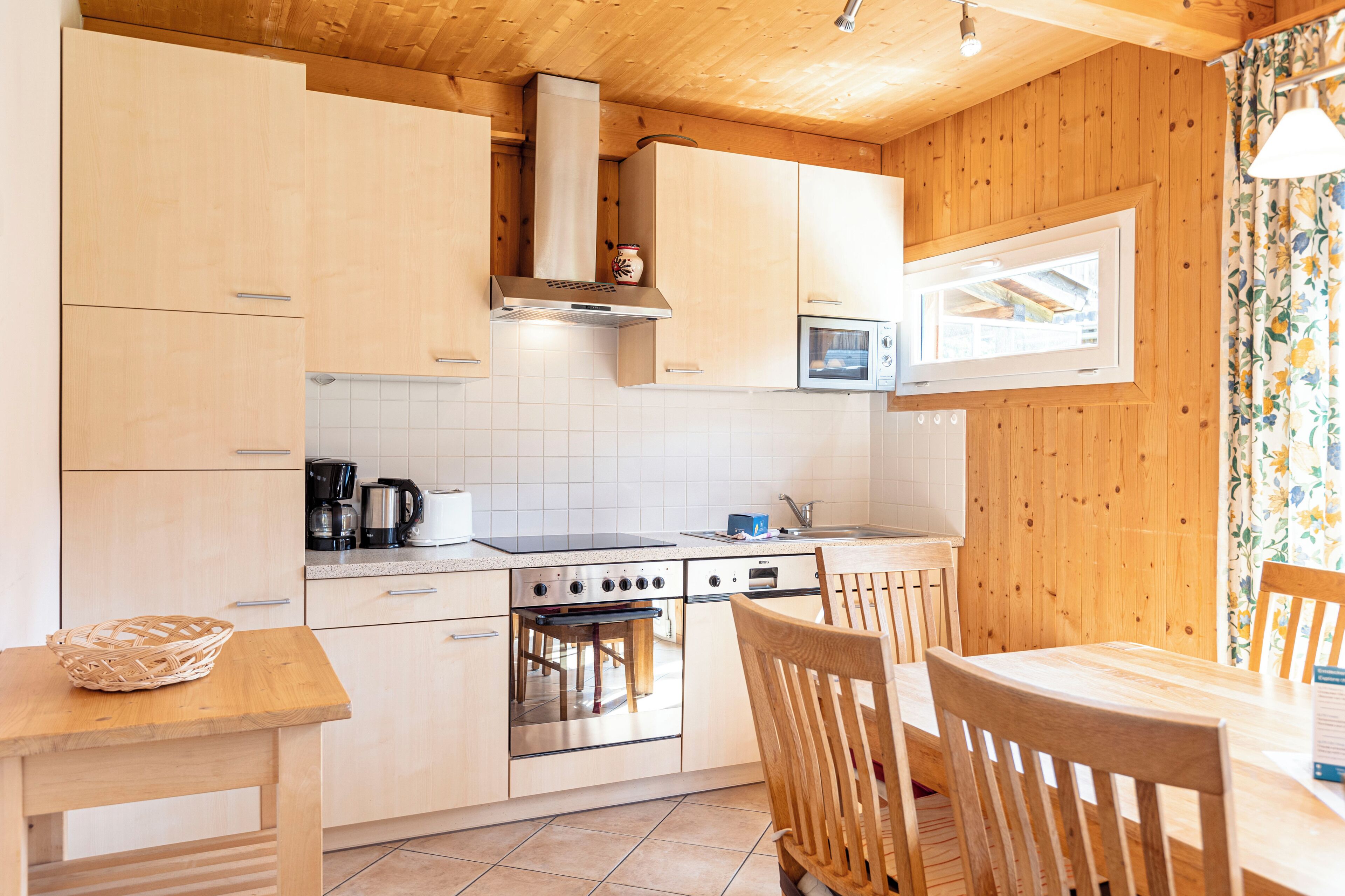 Une cuisine avec des meubles de rangement en bois, une cuisinière et un four à micro-ondes.