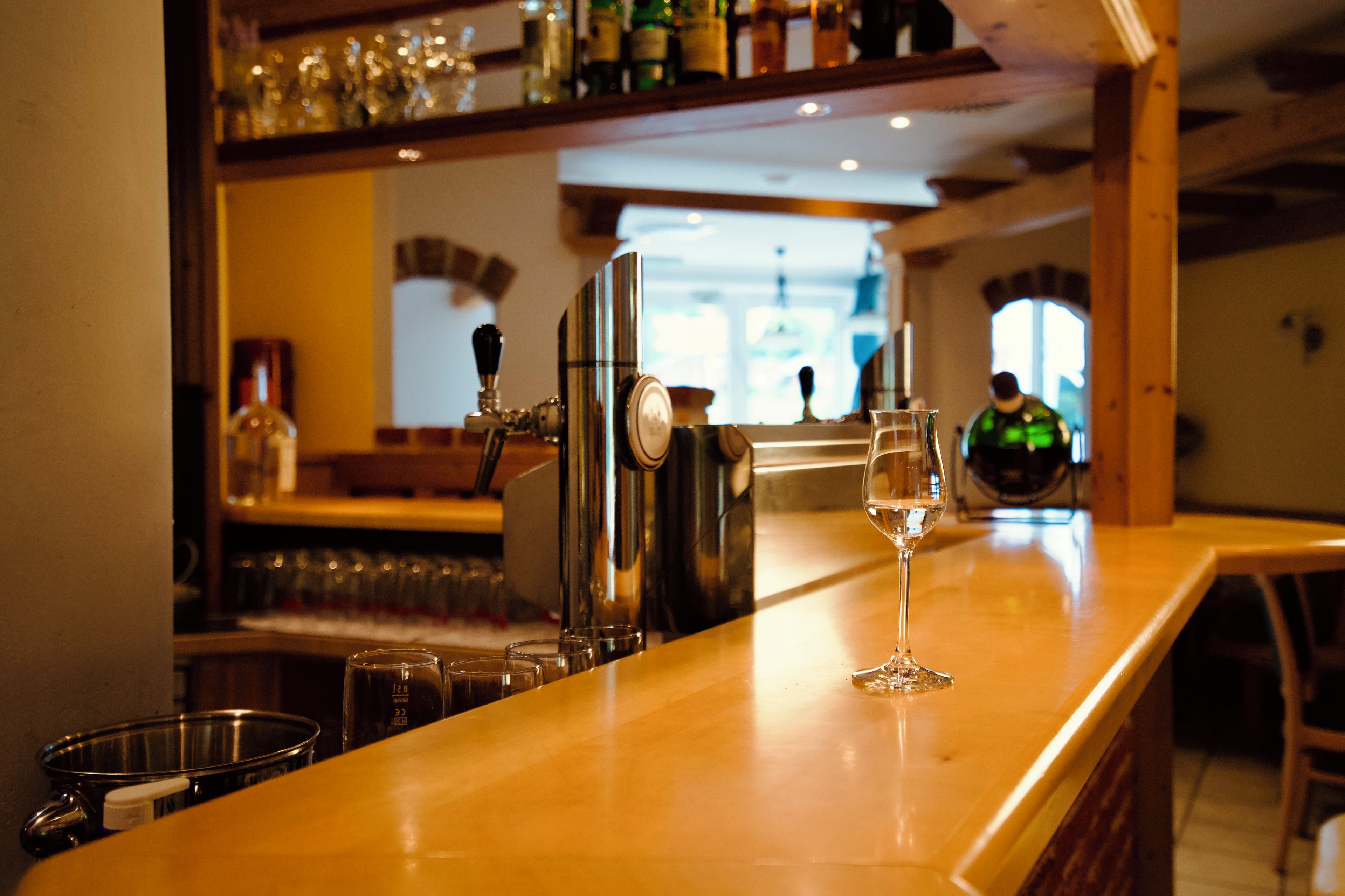 Un espace bar avec un comptoir élégant, un verre d’eau et un robinet.