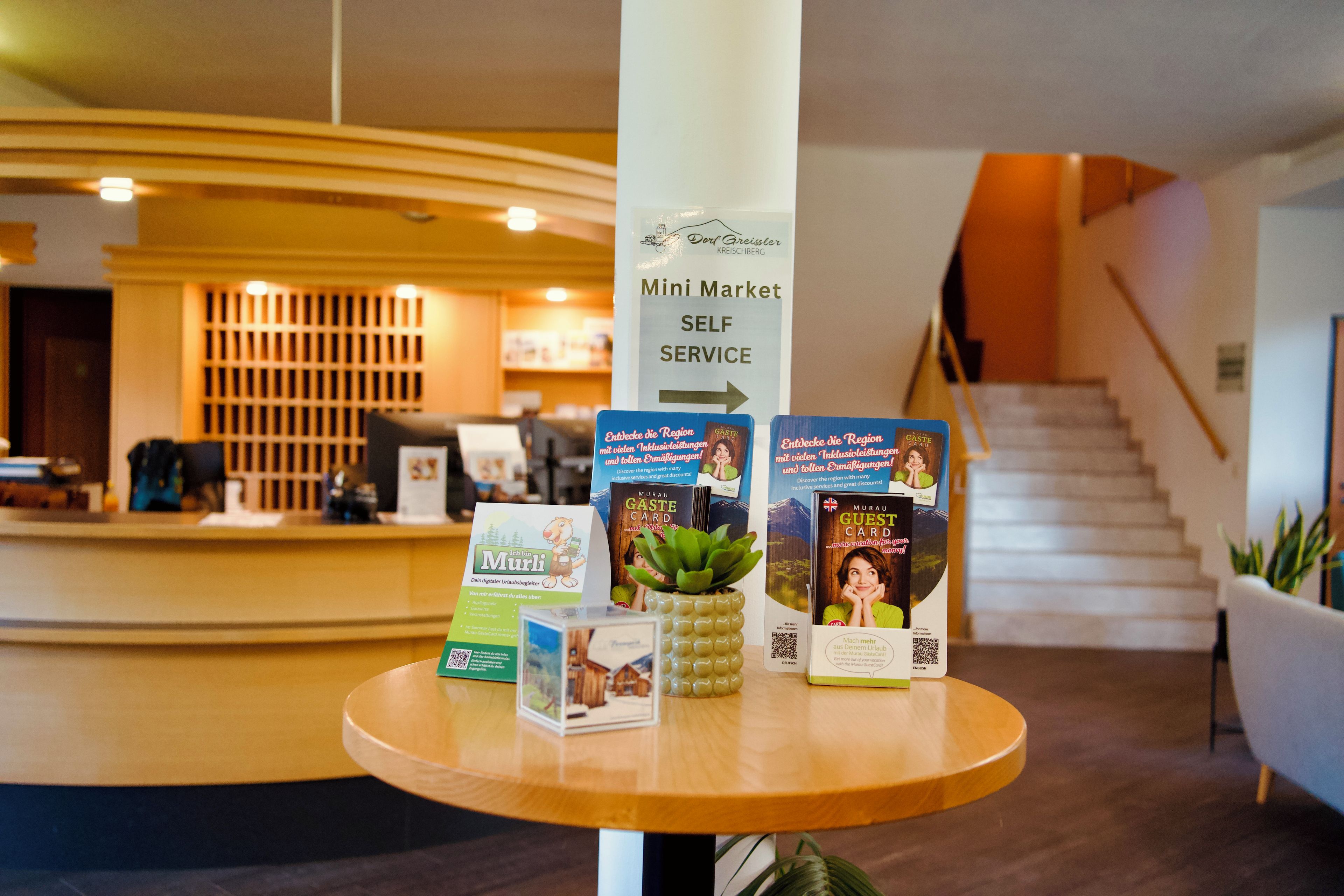 A reception area with a sign for 'Mini Market Self Service' and promotional materials for a card service.