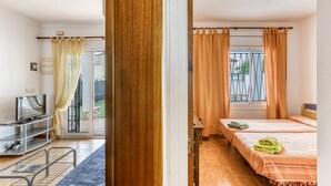 Ein Hotelzimmer mit Bett, Fernseher, Schreibtisch und einem Fenster mit Vorhängen.