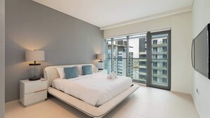 Ein modernes Schlafzimmer mit Bett, Nachttischen und einem Fernseher.