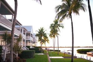 Ein Resort mit Poolbereich, Palmen und Blick auf das Wasser.