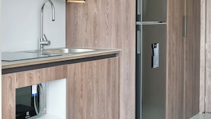 Una cucina moderna con mobili in legno, elettrodomestici in acciaio inossidabile e forno a microonde integrato.