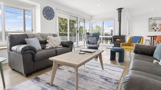 A spacious living room with a sofa, coffee table, and a fireplace.