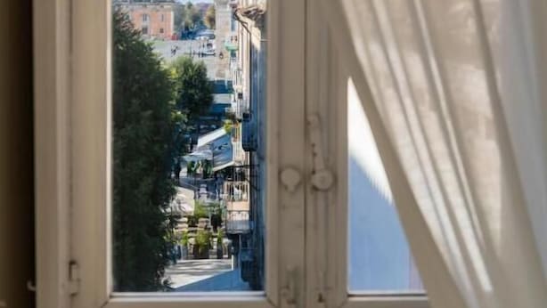 A window with a view of a cityscape through a curtain. - Dimora Margherita (Caserta)