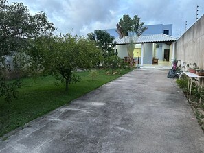 A residential area with a concrete pathway leading to a house with a tiled roof. - BEACH HOUSE (Prado)