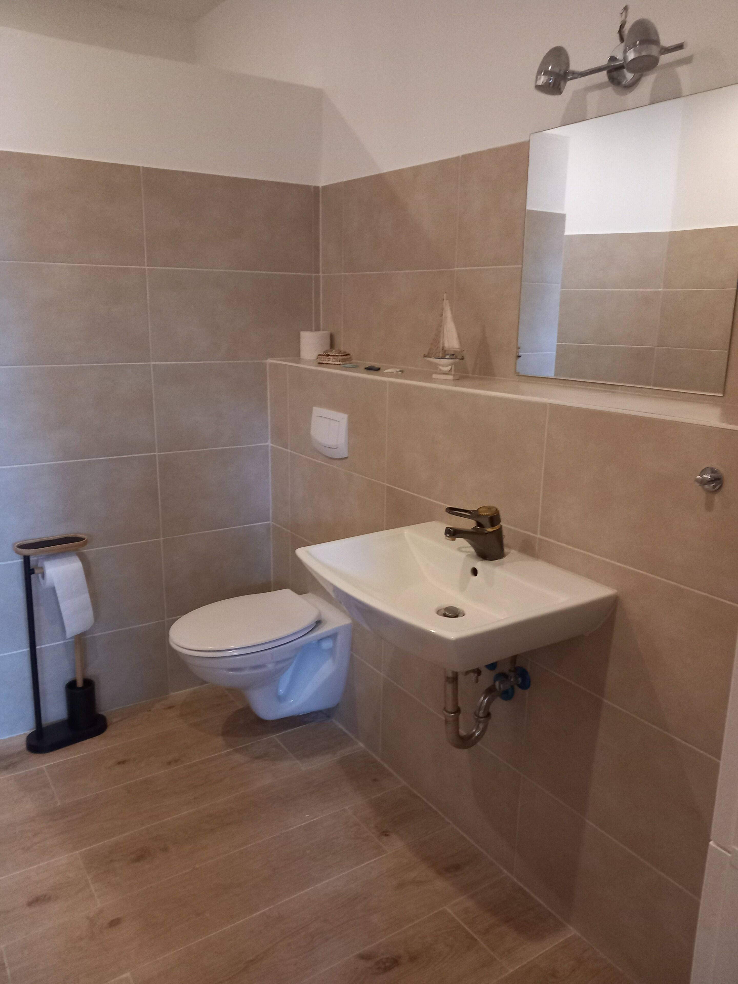 Ein Badezimmer mit Toilette, Waschbecken und Spiegel.