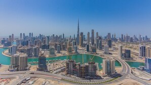 A cityscape with a prominent skyscraper, a marina, and surrounding high-rise buildings. - Spacious 1BR Rental | 1050 sq ft | Luxury Lifestyle in Paramount Towers (Dubai)