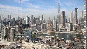 A cityscape with high-rise buildings, a prominent tower, and a marina with boats. - Spacious 1BR Rental | 1050 sq ft | Luxury Lifestyle in Paramount Towers (Dubai)
