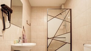 Baño con lavabo, inodoro y zona de ducha.