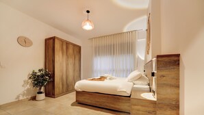 Un dormitorio con cama, mesita de noche y una planta en maceta.