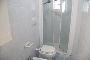 A bathroom with a toilet, a bidet, and a glass-enclosed shower stall. - Townhouse With Garden and Easy Beach Access (Eraclea)