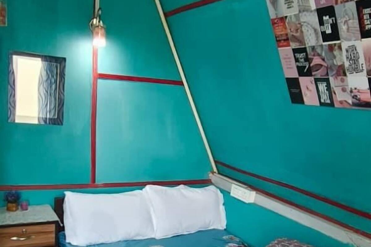 A bedroom with a bed, a nightstand, a wall clock, and a poster.