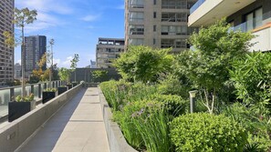 Un chemin bordé de verdure et flanqué de bâtiments modernes.