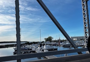 Uma marina com barcos atracados, céu claro e vista para a água.