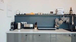 A kitchen with a coffee machine, toaster, and various kitchen utensils on the counter. - 2 room apartment in Hamburg for 6 people (Hamburg)