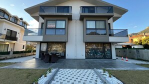 Un bâtiment moderne à deux étages, doté d’un toit plat, de grandes fenêtres et d’un balcon.