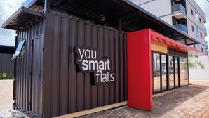 Een modern gebouw met een bord waarop staat 'you smart flats'.