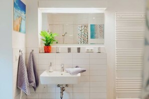 Een haardroger, handdoeken, zeep, toiletpapier