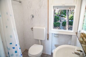 Une salle de bain équipée de toilettes, d’une douche et d’une baignoire.