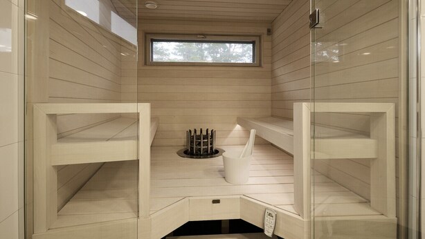 Une salle de bain moderne et minimaliste, avec un lambris en bois, une fenêtre intégrée et un porte-serviettes.