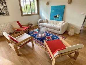 A room with a white sofa, a red and white bench, a glass coffee table, and a patterned rug. - Comfortable penthouse, spacious terrace A0383 (Lège-Cap-Ferret)