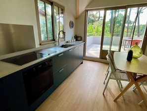 A modern kitchen with a dishwasher, sink, and a dining area with a table and chairs. - Comfortable penthouse, spacious terrace A0383 (Lège-Cap-Ferret)