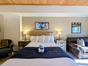 A hotel room with a large bed, two bedside tables with lamps, a brown leather sofa, and a painting on the wall. - New Listing /Updated Studio, Central to Winter Fun (Keystone)