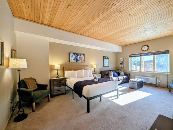 A bedroom with a bed, a chair, a sofa, a heater, and a window with a view. - New Listing /Updated Studio, Central to Winter Fun (Keystone)
