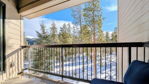 Ein Balkon mit Blick auf eine verschneite Landschaft und Bäume.
