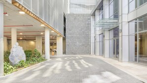 En modern byggnad med ett klinkergolv, en stor stenskulptur och en skylt med texten ”HUI PARK”.