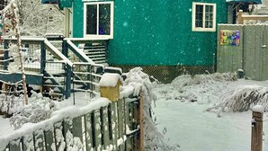 A snow-covered building with a blue roof and a sign that reads "LOVE IS LOVE." - Boho Yurt Stay ~ Cozy & Unique ~ Massage Chair (Athens)