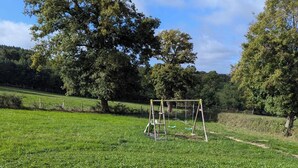 Un champ d’herbe avec une balançoire au centre.