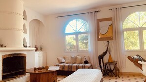 Una habitación con chimenea, sofá, cama y mesa de comedor.