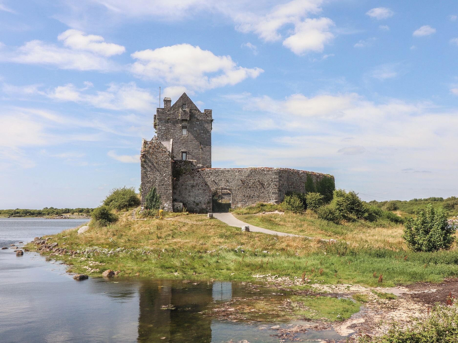 Eine historische Burg aus Stein mit einem Turm, gelegen an einem Fluss.