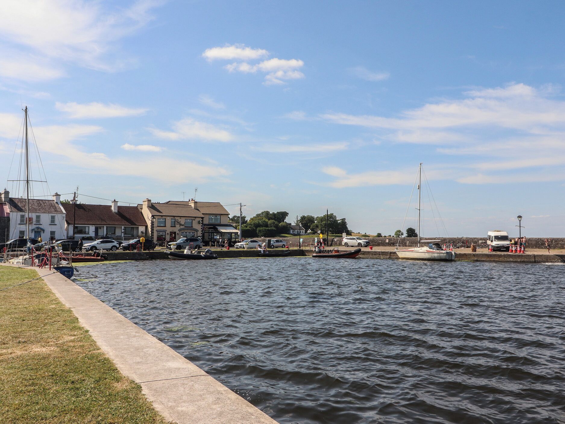 A waterfront area with buildings, a dock, and boats.
