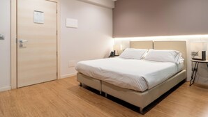Un dormitorio moderno con cama, mesitas de noche y una puerta.