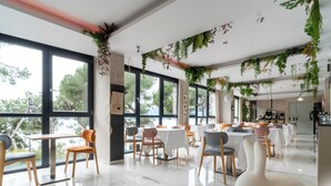Un restaurante moderno con ventanas amplias, sillas y mesas de madera.