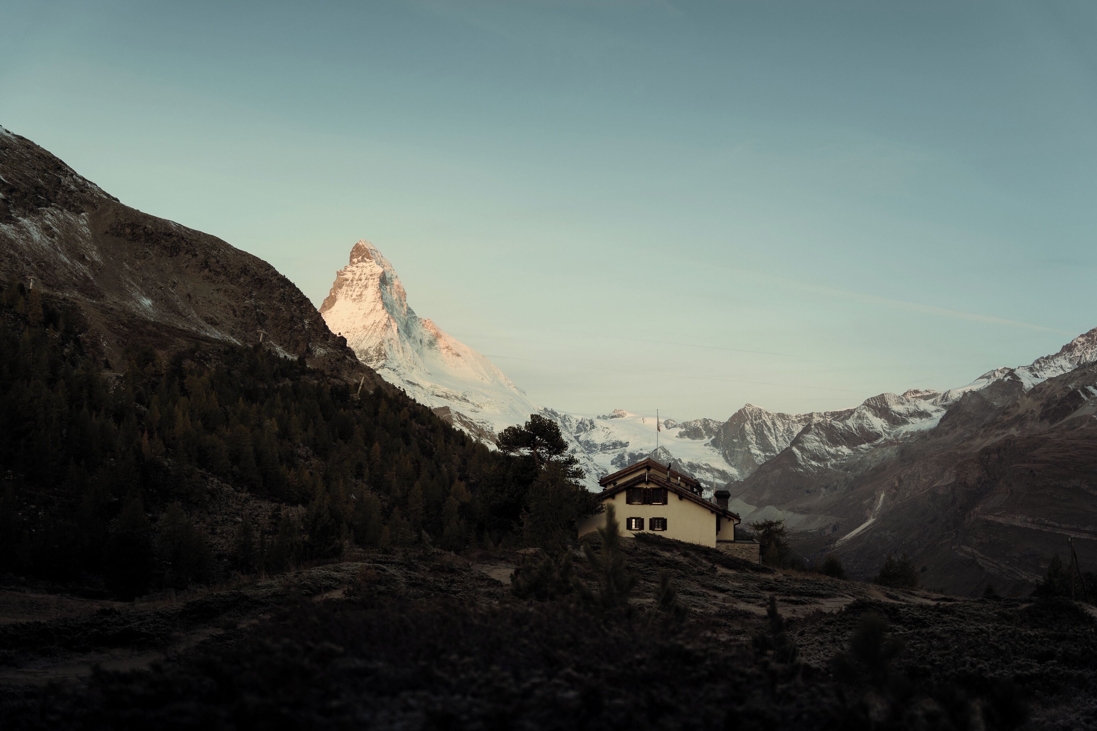 A mountain lodge with a view of a snow-capped peak.