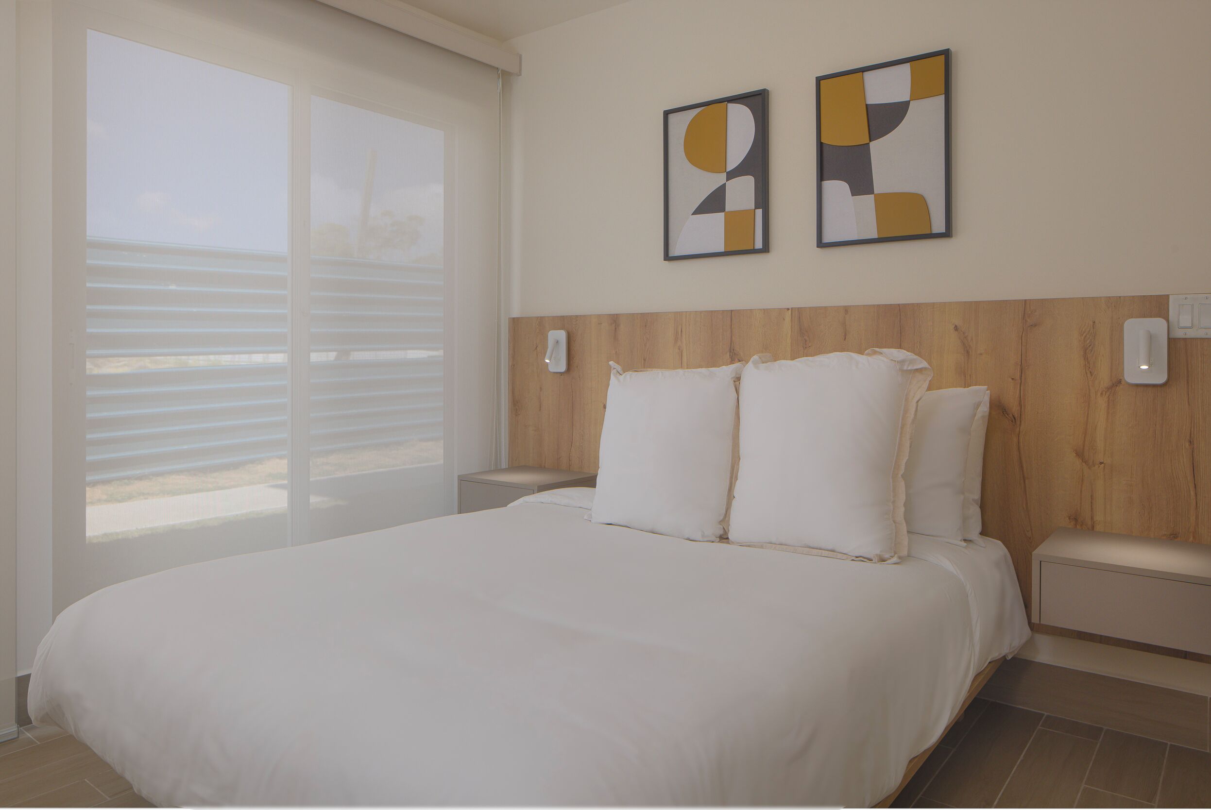 Quarto com uma cama grande, cabeceira de madeira, duas mesas de cabeceira e uma janela com persianas.